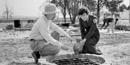 Archeologist JC Harrington and assistant examining an artifact from a well