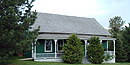 Green house with front porch.