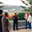 A ranger in his straw hat talks with people of various ages on the Mansion porch; behind him are fields and hills. Photo by Jon Gilbert Fox