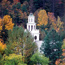 The white steeple of a church is visible through the treetops. Photo by Ed Sharron.