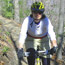 Bicycle rider (wearing helmet) riding on a mountain bike trail