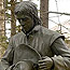Bronze statue shows French man in mourning, holding his hat.