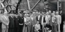 Jurors and court officials pose in front of the forge waterwheel