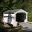 Small, white covered bridge crossing over the narrow Valley Creek.
