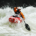 kayacker paddles through whitewater