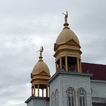 Gold domes of ornate church with angel statues on top