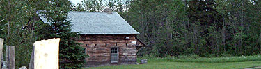 A log house sits in the woods.
