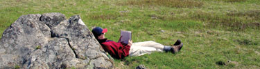 A visitor relaxes against a large rock in Big Meadows.