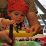 Close-up of child coloring with her guardian.