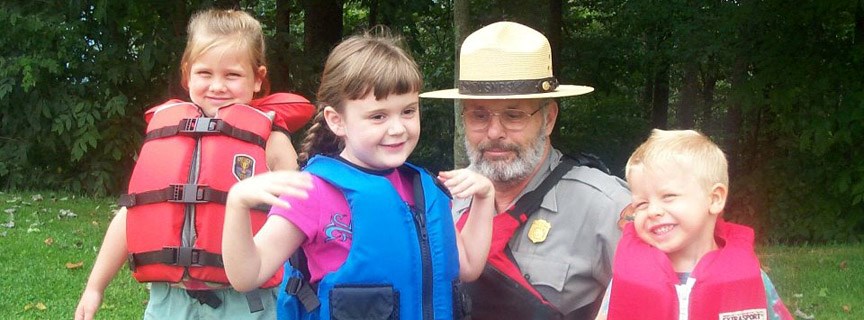 ranger with kids trying on life jackets