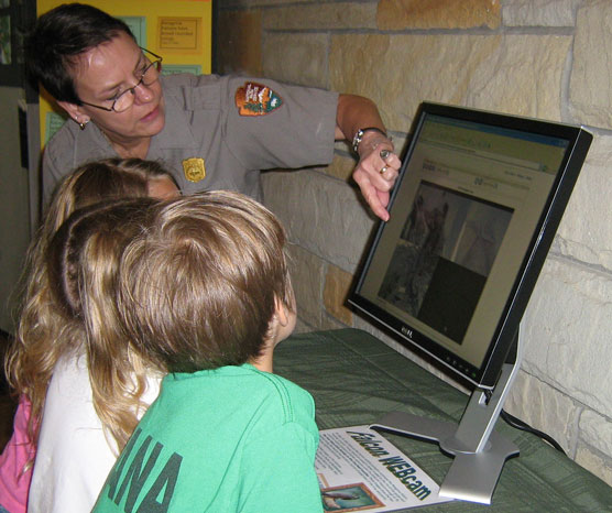 Ranger and young park visitor looking at video of peregrine program.