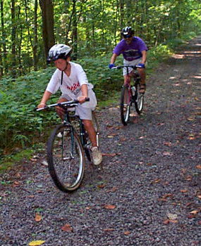 Two bicyclists riding on gravel/dirt trail