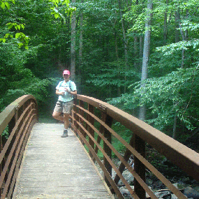 hiker crossing footbridge on Glade Creek Trail