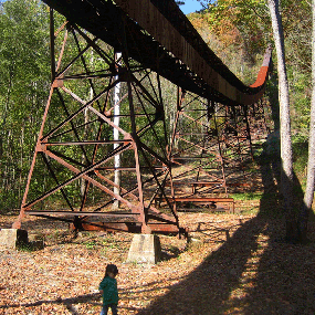 young hiker walking under coal conveyor