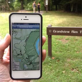 hand holding smart phone with park trails app
