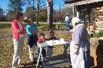 Families watch reenactor bake in beehive oven