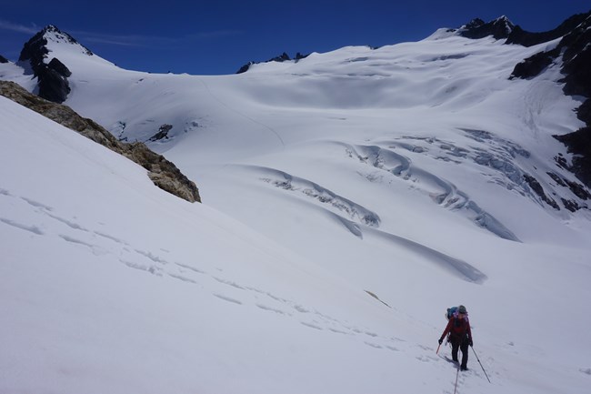 A North Cascades National Park Ranger ascends to the Colonial/Neve Col from the Neve Glacier