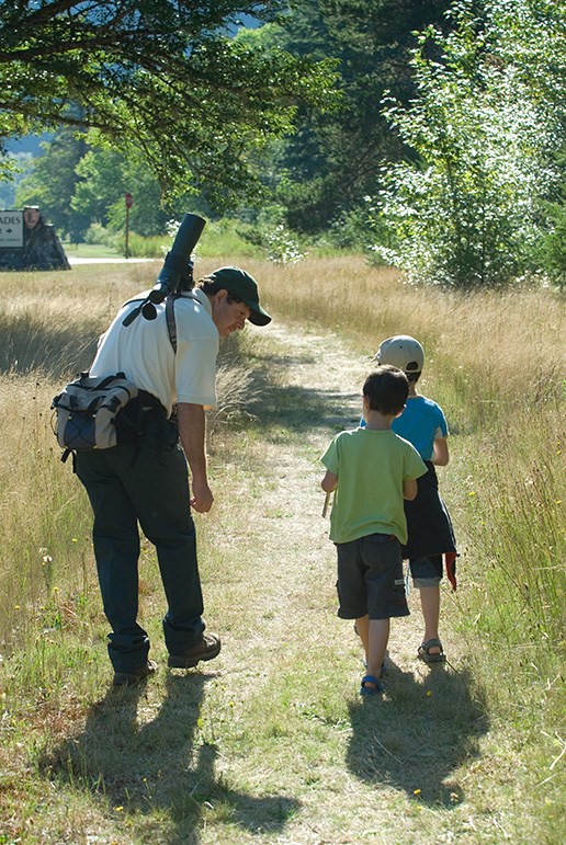 Young visitors join a birdwatching expert on a morning walk. Image Source: NPS/NOCA/David Snyder