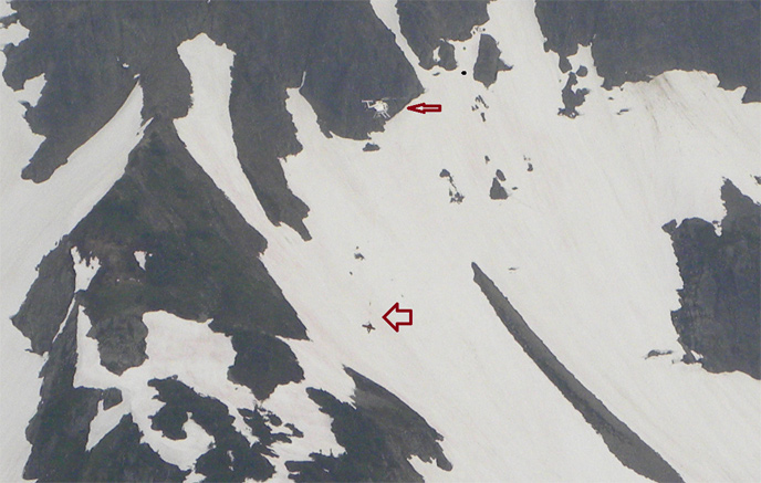 Helicopter evacuation of injured climber from Sahale Peak. (Arrows help to illustrate the helicopter and the patient on a litter with ranger.) Image Credit: NPS/NOCA