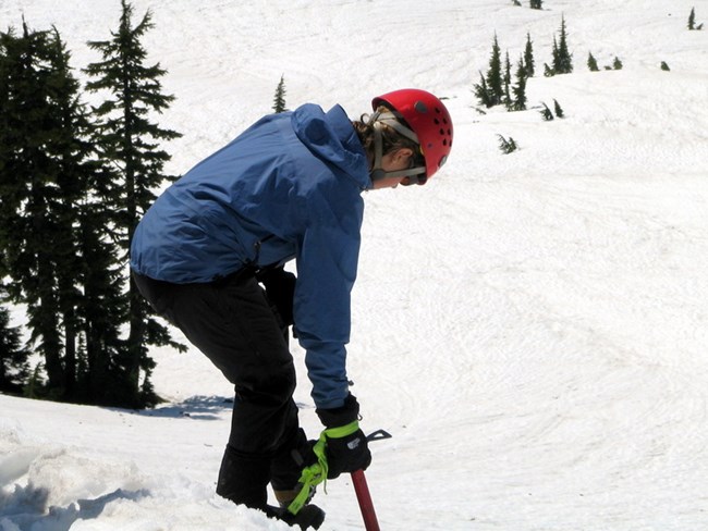 Using an ice axe to descend steep snow