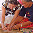  Samoan woman showing visitor how to weave the laufala mat.