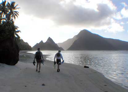 Two beachwalkers with snorkle gear in early light at Ofu.