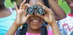 Photo of a girl looking through binoculars at Fort Dupont Park 