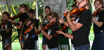 Photo of a group of fiddlers on stage