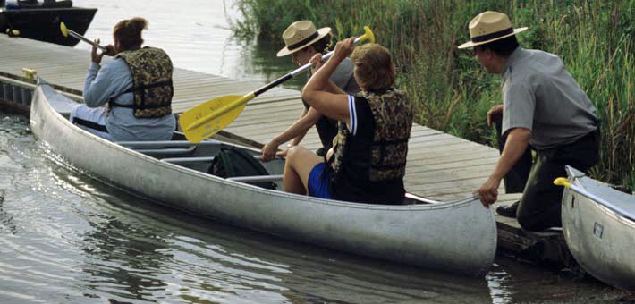 Photo of rangers helping visitors launch a canoe during a guided program on the Missouri National Recreational River (NPS photo)