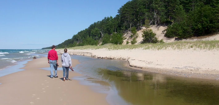 Photo of two people walking along Twelvemile Beach at Lake Superior in the Beaver Basin Wilderness  
