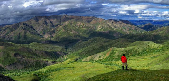 Photo of a hiker looking out onto the Big Creek drainage in the Denali Wilderness, Denali National Park and Preserve, Alaska (NPS Photo, Jacob W. Frank)