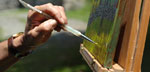 Photo of an artist's hand and painting at Weir Farm