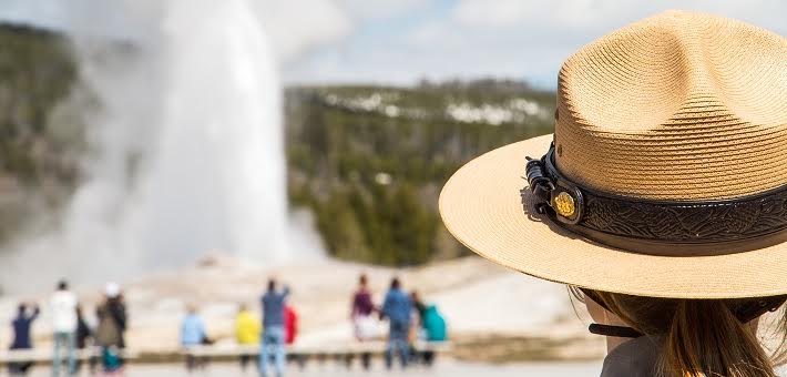 Ranger and visitors watching geyser at Yellowstone