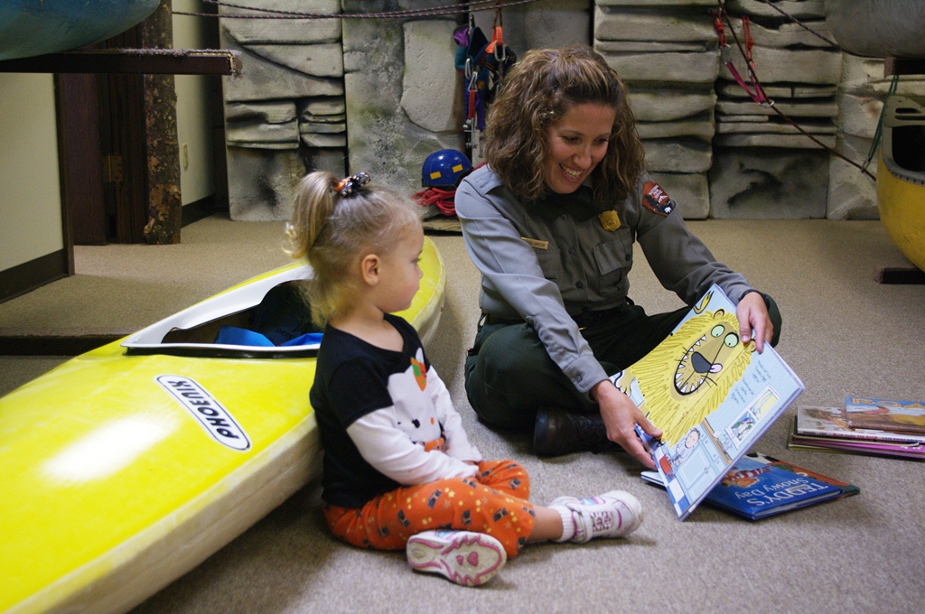 Ranger reading from storybook for little girl