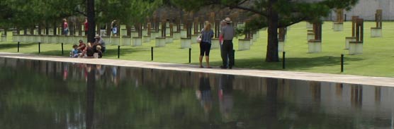Park rangers and visitors reflected in a pool of water