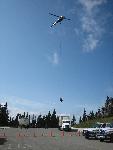 Helicopter loads tires into waiting truck.