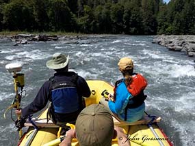 Two member of the inter-agency sediment team survey the Elwha River from a raft.