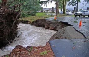 road damaged by rushing creek waters