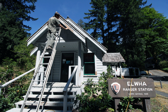 employee on ladder working on outside of Elwha Ranger Station