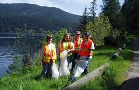 four women in reflective vests beside a lake