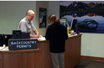 man helps woman at information desk