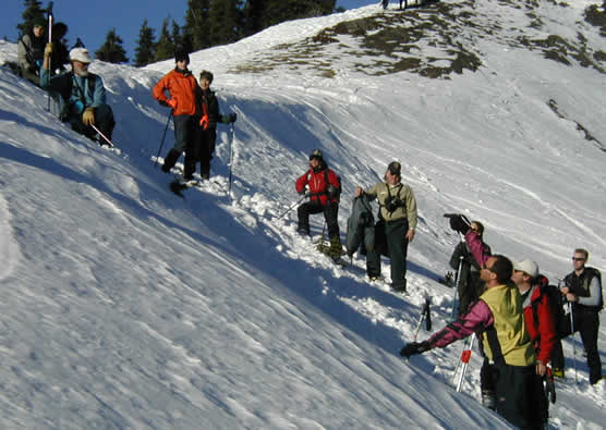 people standing on steep snow-covered slopes