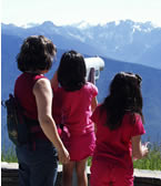 three dark-haired girls looking at Olympic Mountains