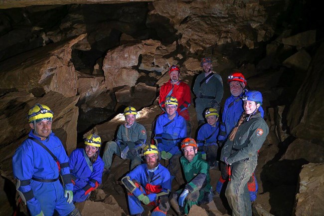 Several rangers in off trail gear in the cave.