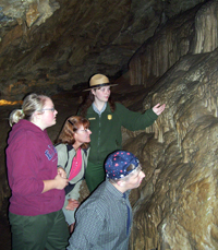 A Ranger shows visitors flowstone formations on a cave tour.