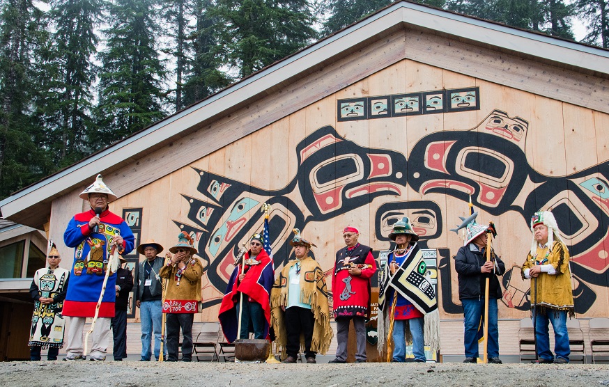 Members of the Huna Tlingit clans standing in front of the Huna Tribal House