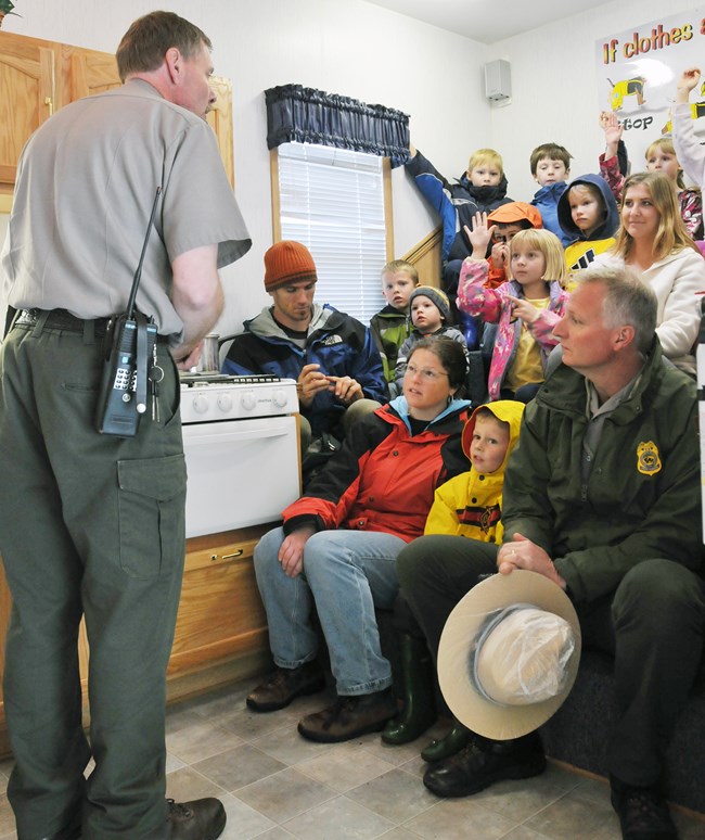 Park ranger talks to a group of children and adults about fire prevention