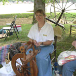 Woman demonstrating a spinning wheel. Traditional skills are demonstrated in ranger programs.