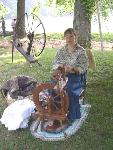 Woman demonstrates spinning wheel