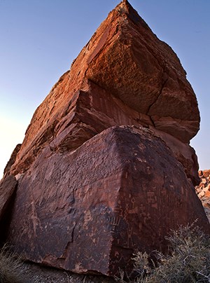 towering rock covered in petroglyphs on two sides